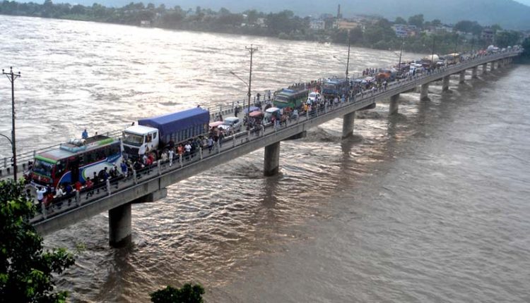 onlookers gather at the Narayani Bridge in Chitwan